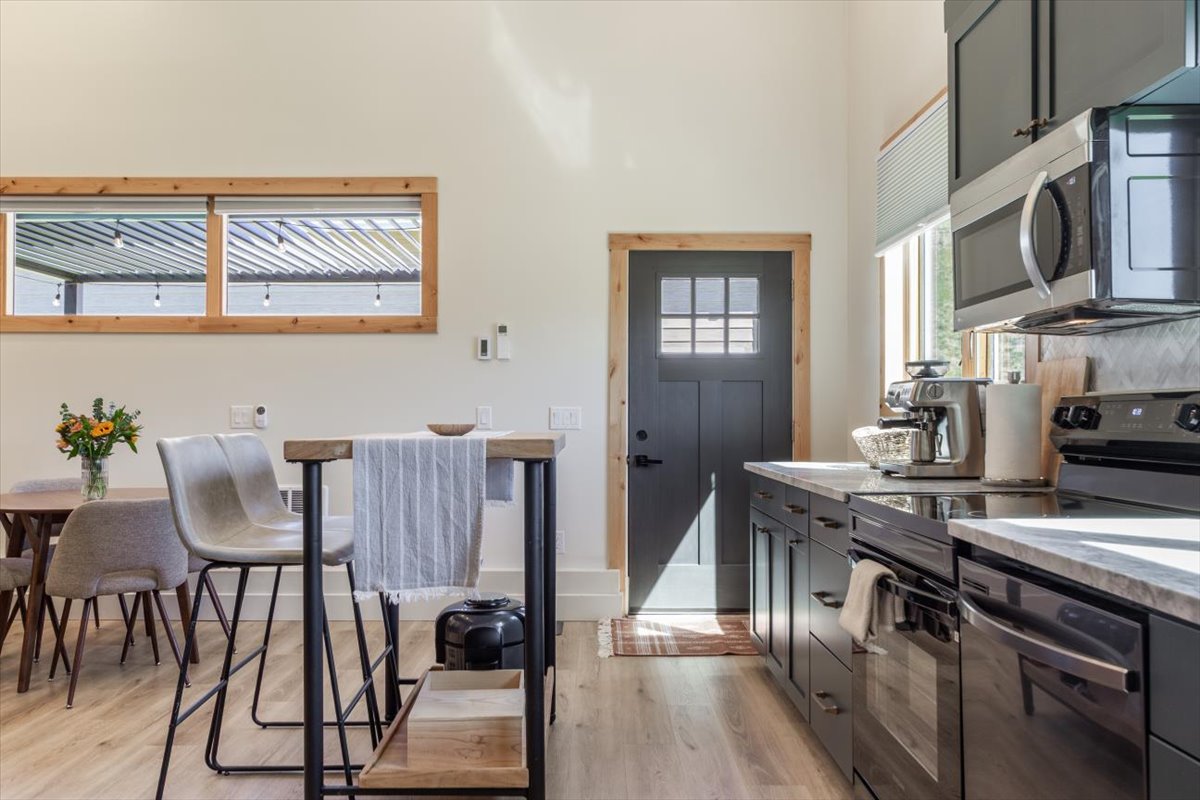Dining table and butcher-block bar seating beside the entry