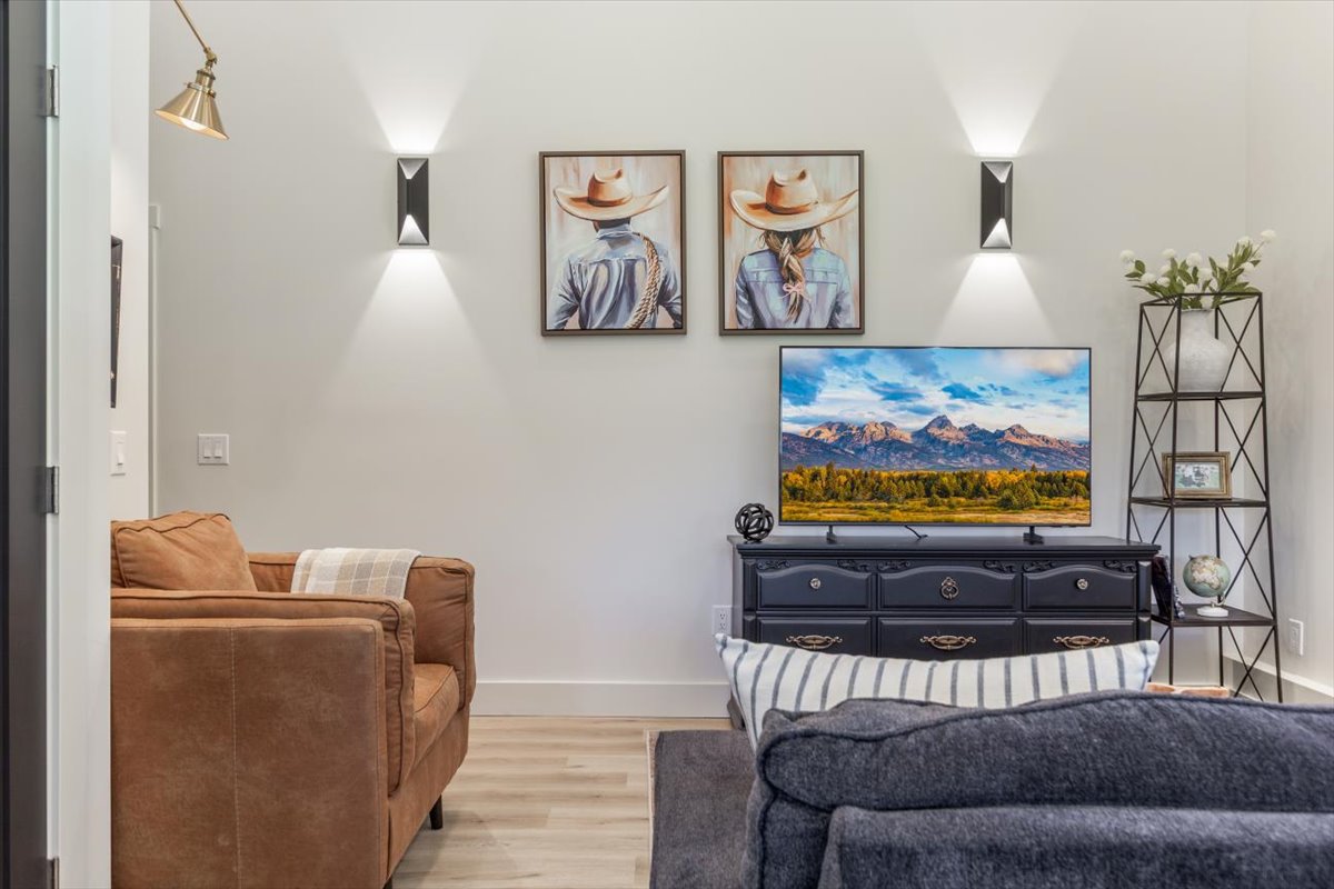 Living room seating with leather sofa, smart TV and Western art