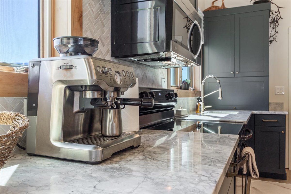Fully equipped kitchen with espresso machine and marble counters