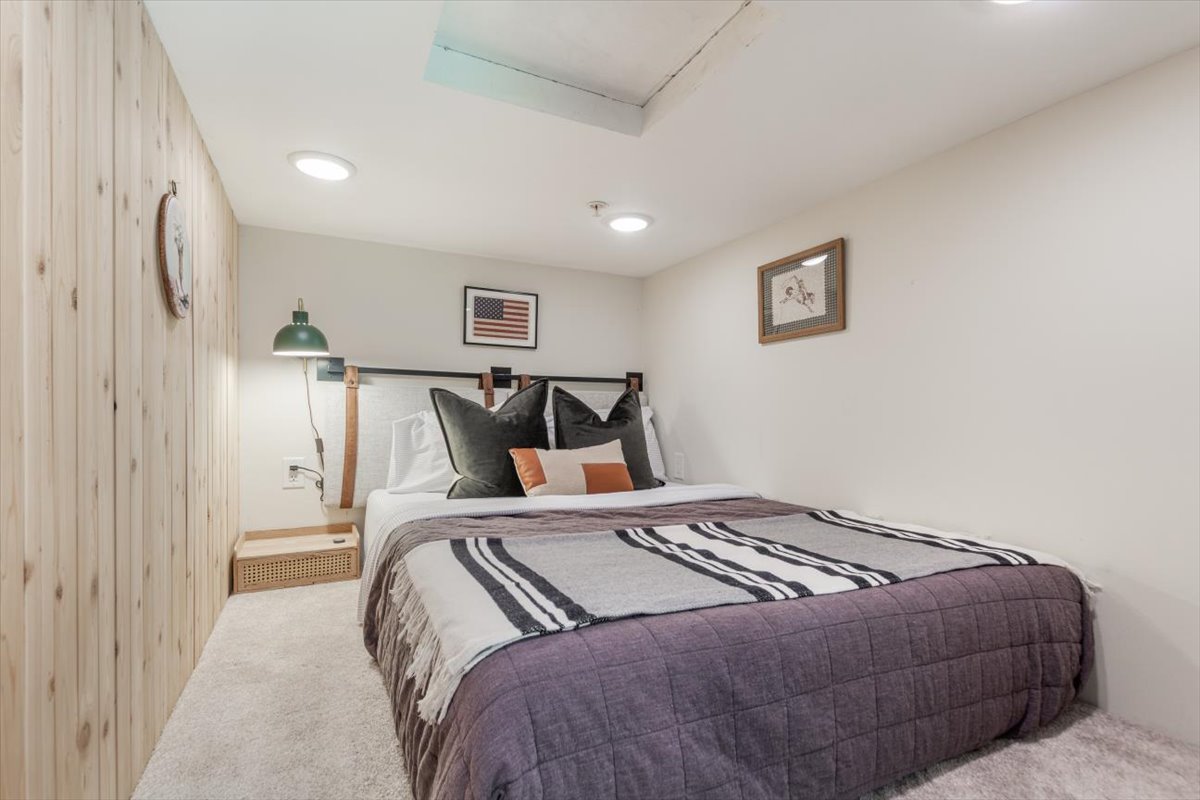 Cozy sleeping loft with double bed and pine paneling