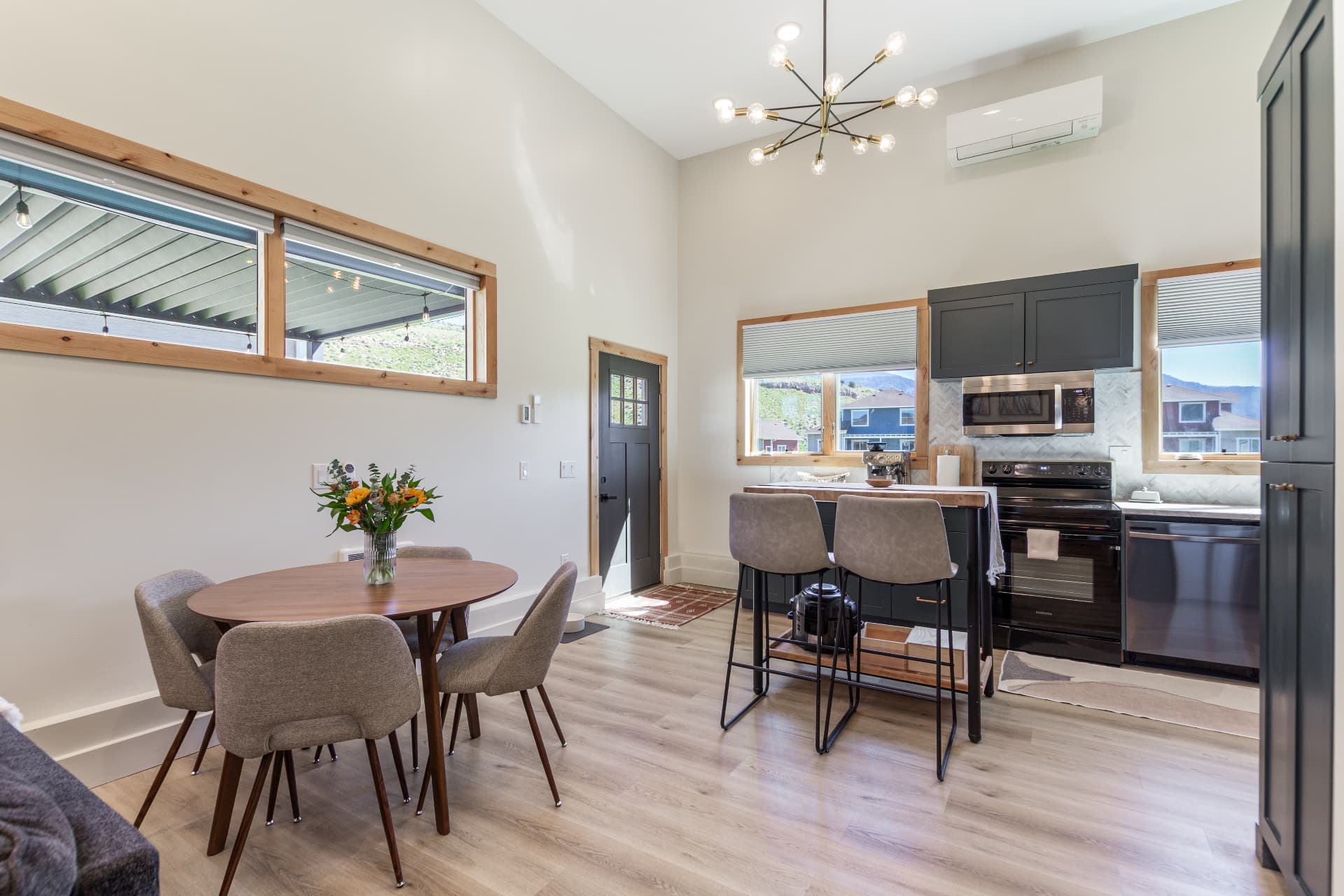 Round dining table for four beside the entry and kitchen island
