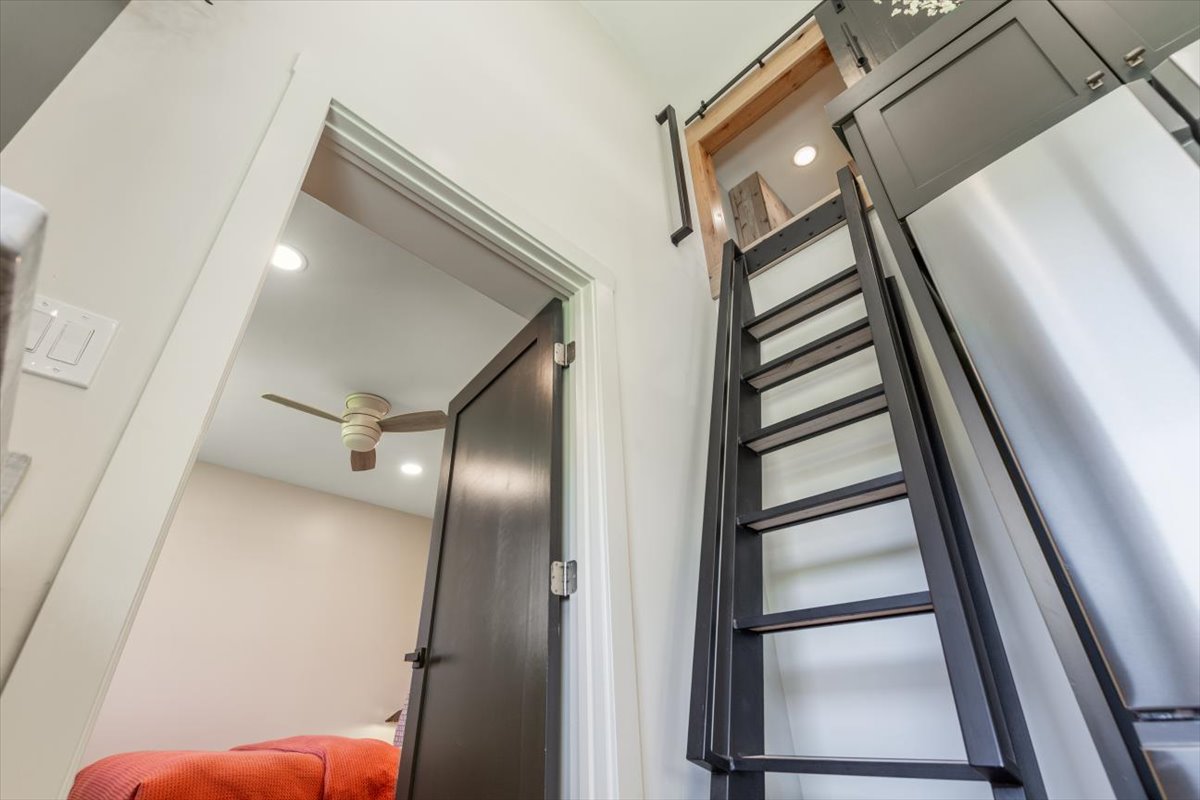 Ladder access to the sleeping loft behind a sliding barn door