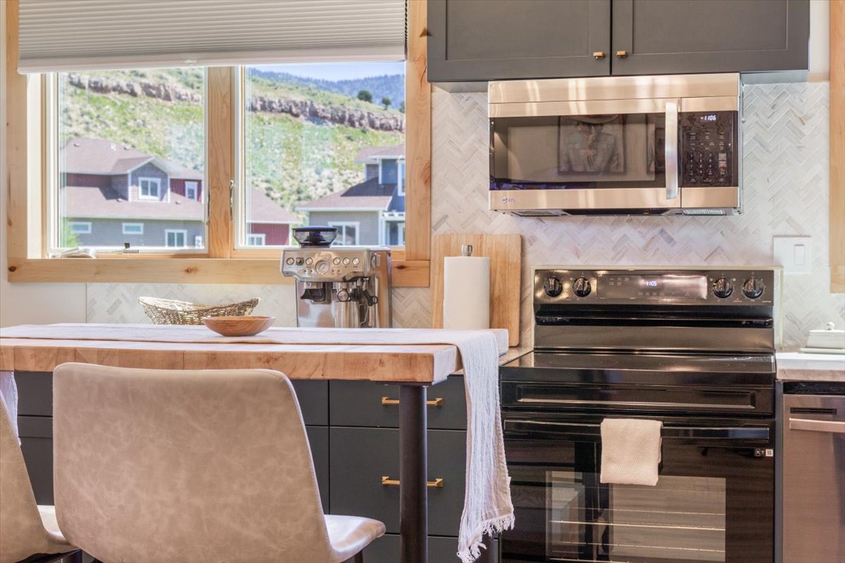 Bar seating at the butcher-block island with espresso machine