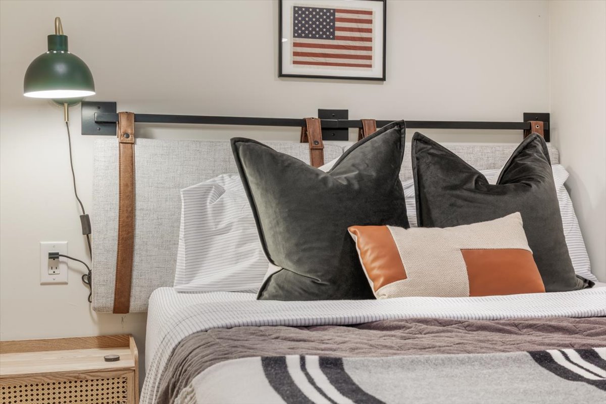 Western-inspired bedding and leather-strap headboard detail