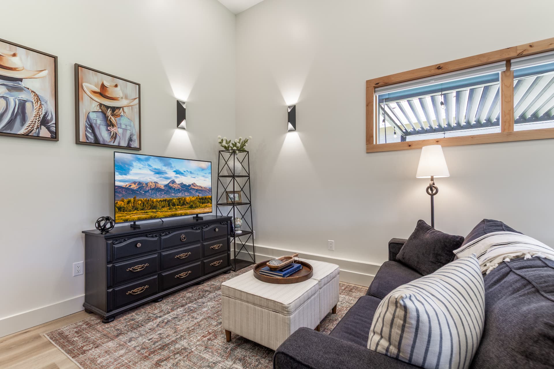 Second living space with smart TV, cowgirl artwork and sleeper sofa